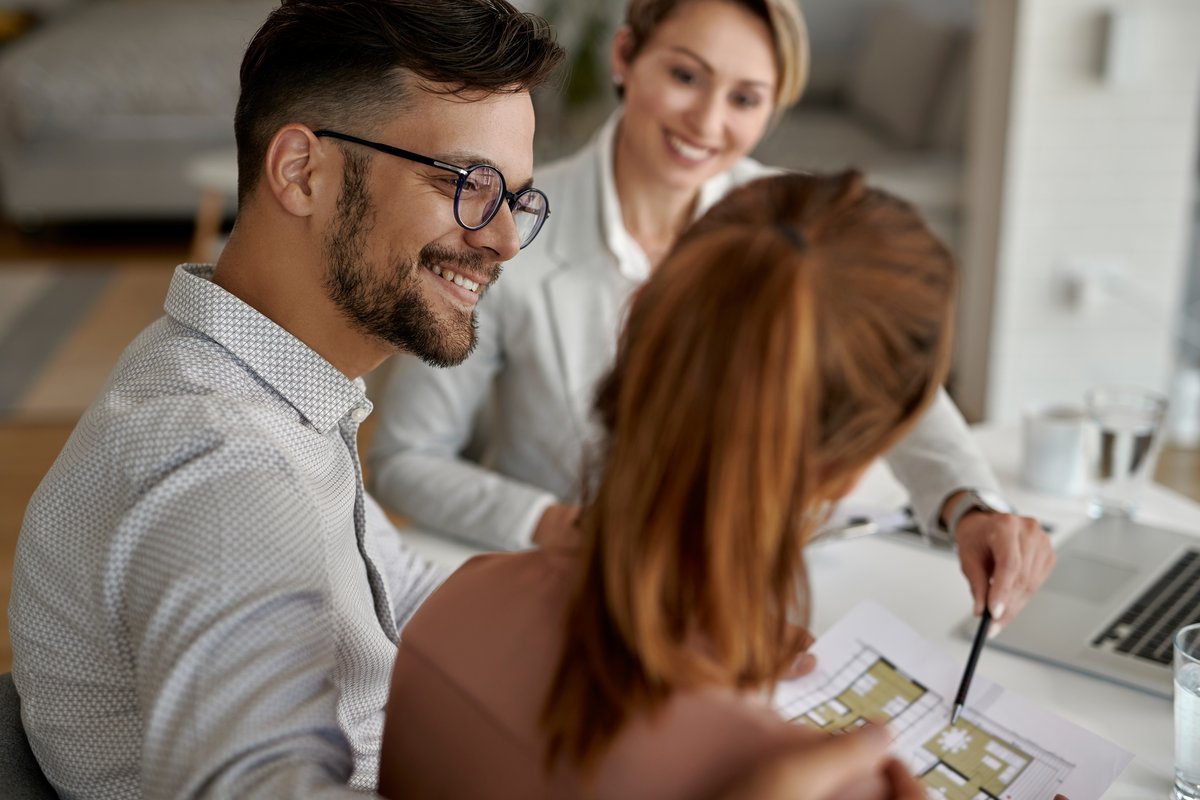 Two agents reviewing a floor plan with clients at a table