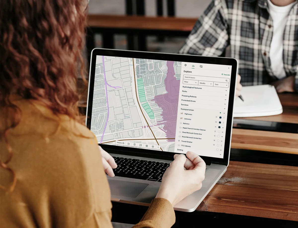 A person reviewing zoning and transportation map layers on a laptop